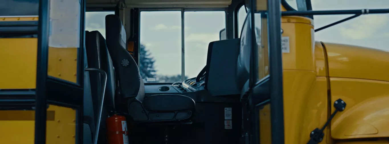 Wingate Elementary School Yellow School Bus with Door Open and Empty Driver Seat.
